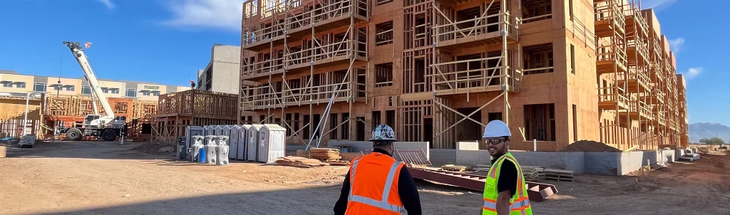 construction site with workers and building framing for new residential development